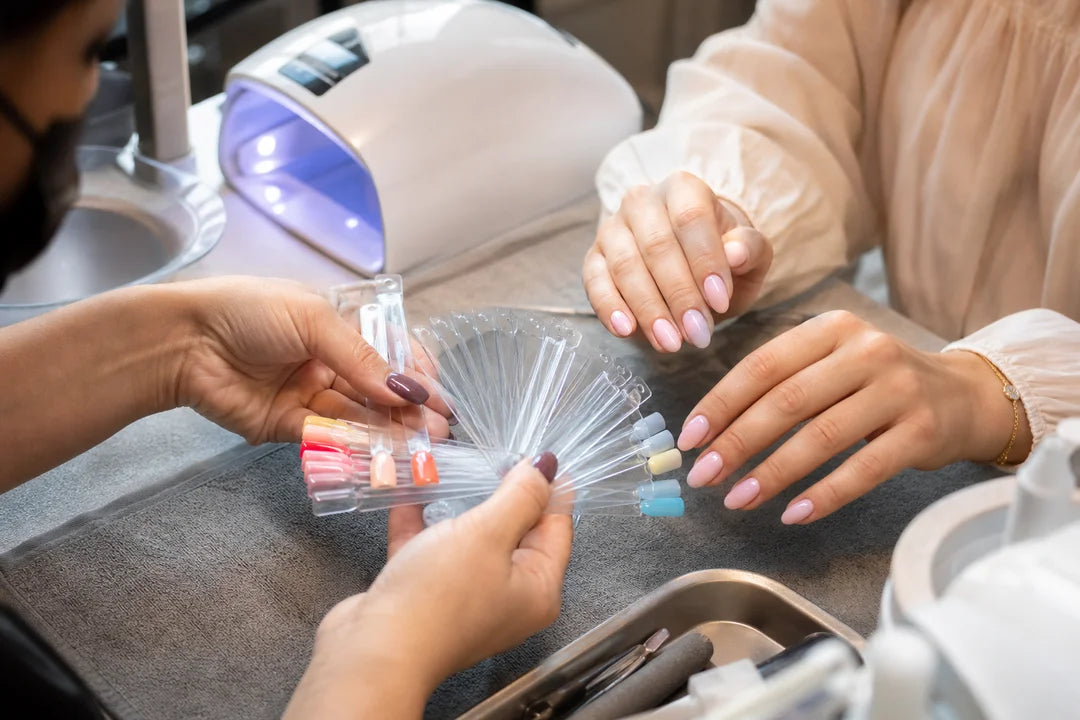 Letnie paznokcie 2026 - stylistka dobiera kolory manicure w salonie